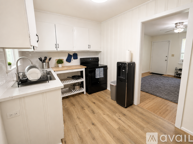 A kitchen with white cabinets and a wooden floor.
