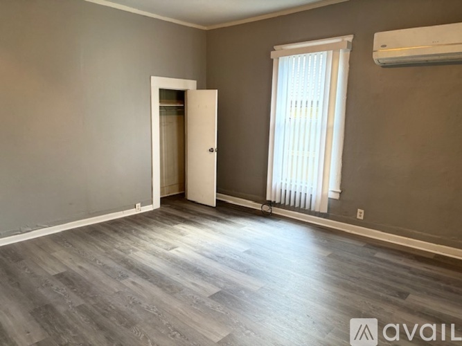 A room with a door, window, and air conditioner.