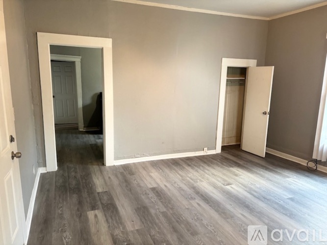 A room with a wooden floor and two white doors.