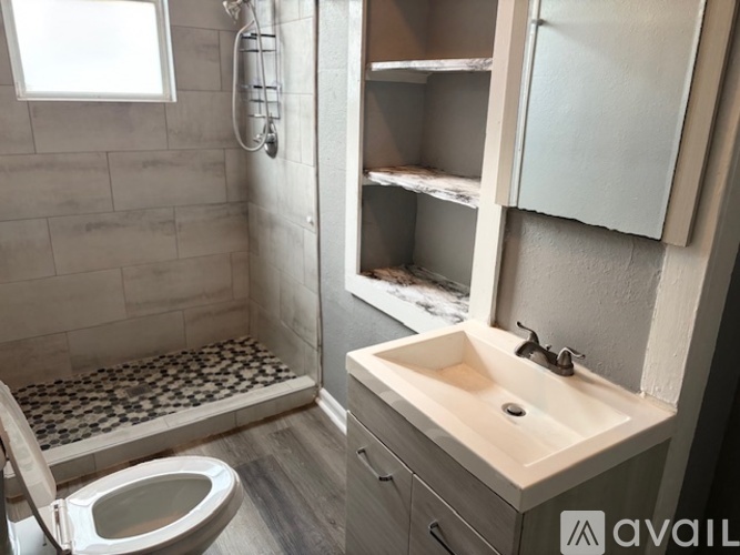 A bathroom with a toilet, sink, and shower.