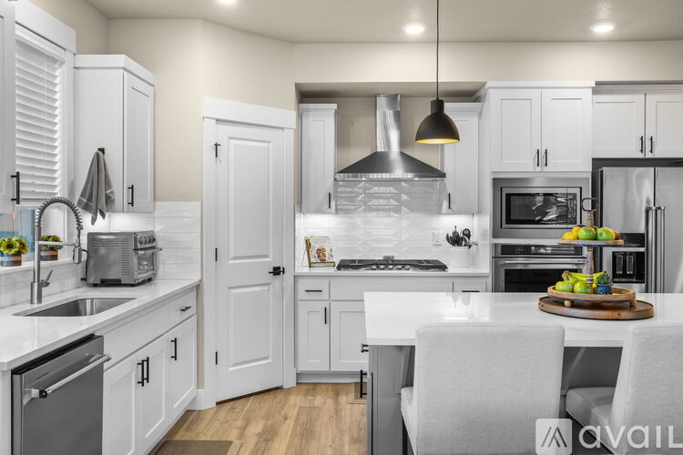A modern kitchen with white cabinets and appliances.
