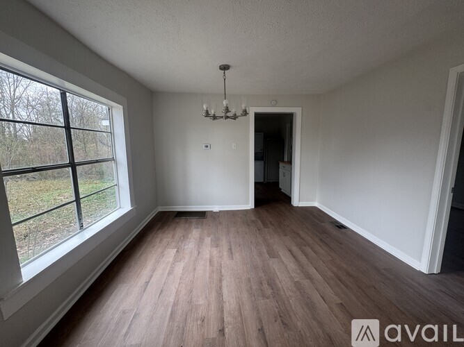 A room with wooden floors and a chandelier.