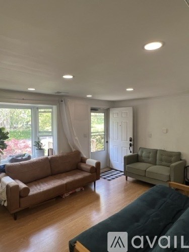 A living room with a brown couch and a green couch.
