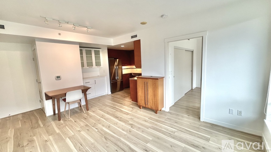 A room with wooden flooring and a white wall.