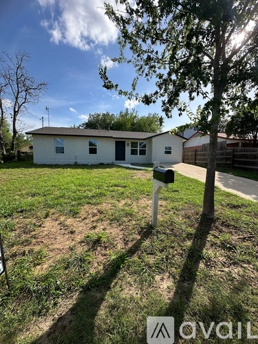 A small white house with a black mailbox in front of it.