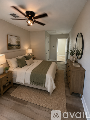 A bedroom with a bed, nightstand, and a ceiling fan.