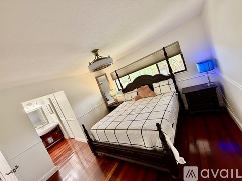 A bedroom with a four poster bed and a window.