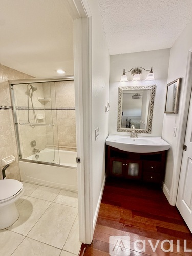 A bathroom with a toilet, sink, and mirror.