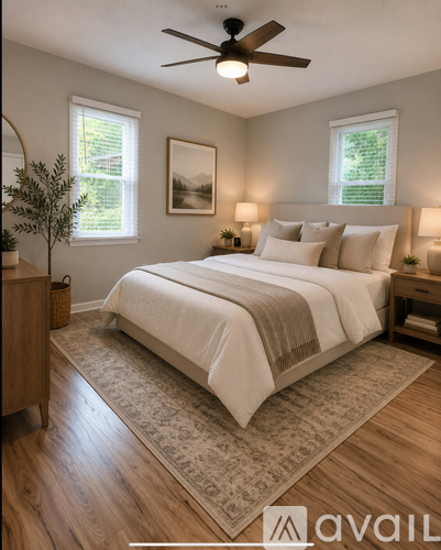A bedroom with a large bed and a ceiling fan.