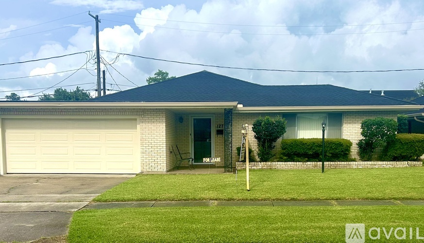 A house with a garage and a sign that says "available" in the front yard.