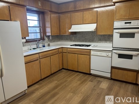 A kitchen with wooden cabinets and white appliances.