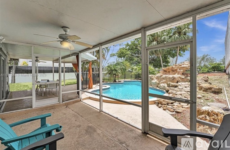A patio with a pool and a ceiling fan.