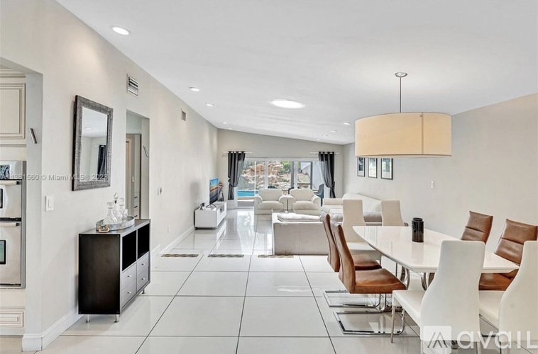 A modern kitchen with white cabinets and a dining table with chairs.