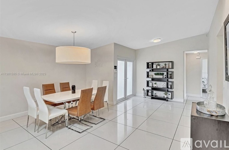 A modern dining room with a white table and chairs.