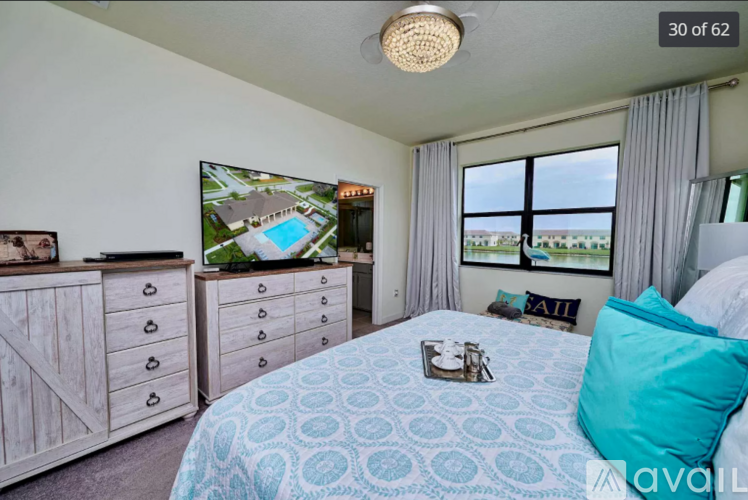 A bedroom with a large bed and a television displaying a house with a pool.