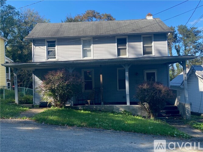 A two-story house with a porch and a front yard.