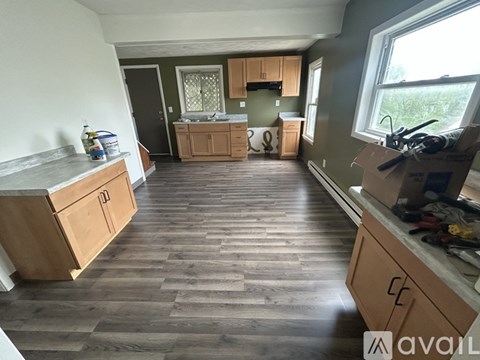 A kitchen with wooden cabinets and a countertop is available for rent.