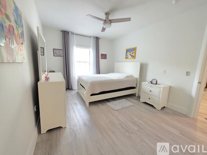 A bedroom with a bed, dresser, and nightstand.