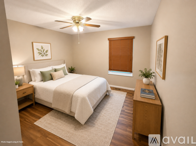 A bedroom with a bed, nightstand, and a ceiling fan.