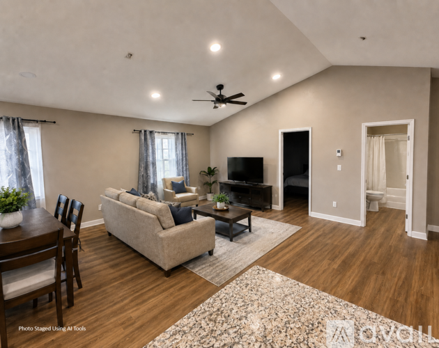 A living room with a couch, a coffee table, and a television.