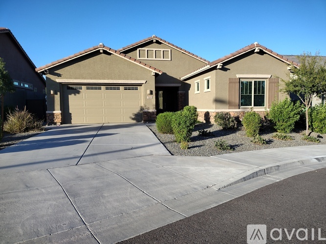 A house with a garage and a driveway in front of it.