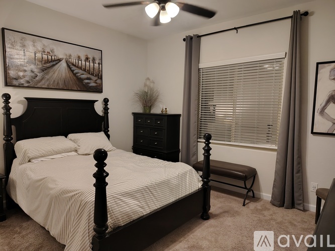 A bedroom with a large bed and a ceiling fan.