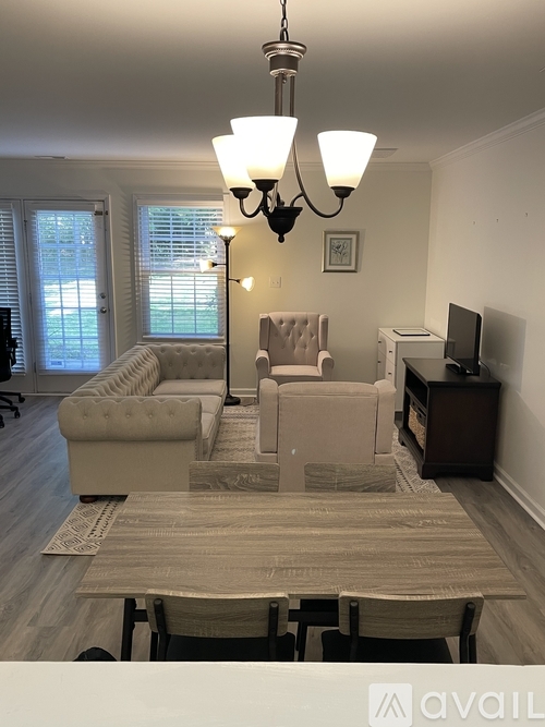 A living room with a couch, chair, and television.