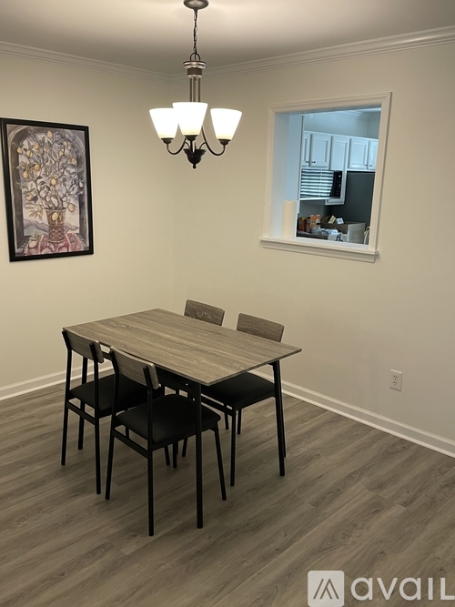 A dining room with a wooden table and chairs.