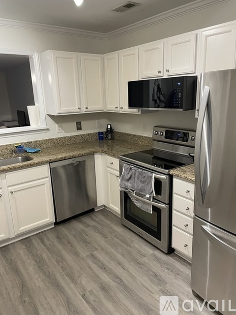 A kitchen with white cabinets and stainless steel appliances.