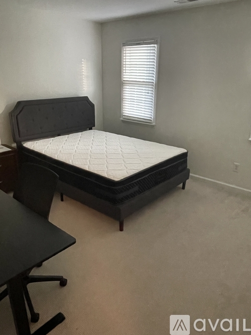 A bedroom with a bed, desk, and chair.