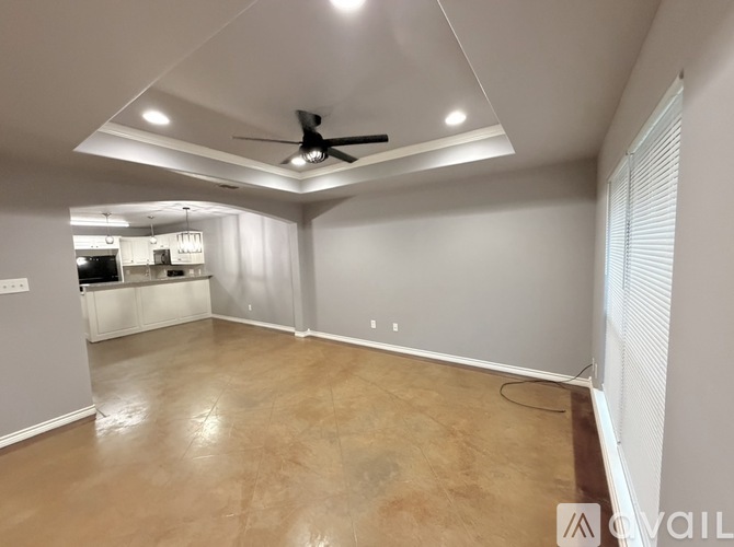 A spacious room with a ceiling fan and a tiled floor.