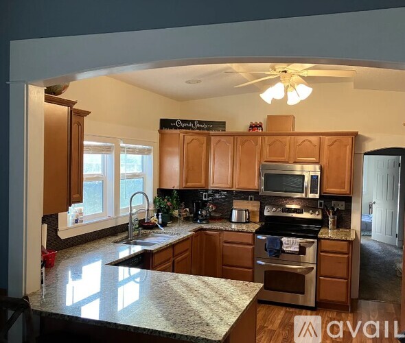 A kitchen with wooden cabinets and granite countertops.