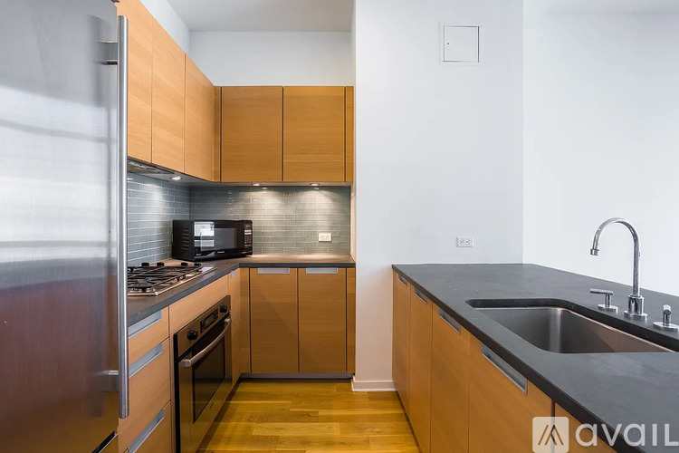A kitchen with wooden cabinets and a black countertop.