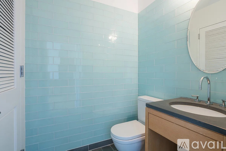 A bathroom with a toilet, sink, and mirror.