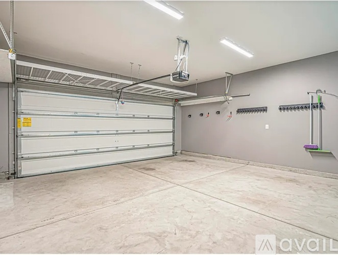 A spacious garage with a closed white door and a wall-mounted rack.