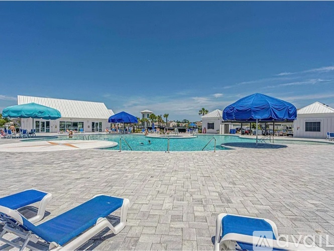 A sunny day at the pool with blue lounge chairs and umbrellas.