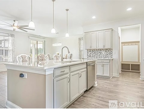 A kitchen with a white ceiling and a wooden floor.