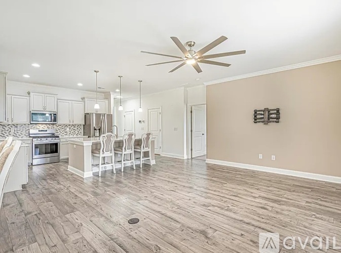 A living room with a wood floor and a ceiling fan.