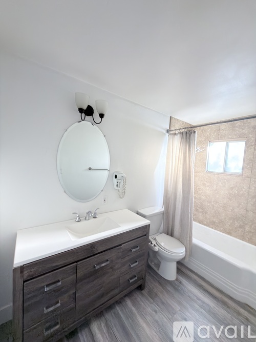 A bathroom with a sink, toilet, and a mirror.
