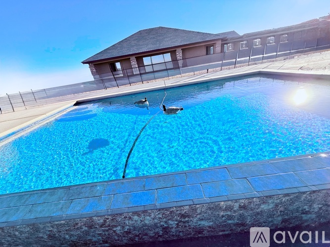 A swimming pool with a sunny sky in the background.