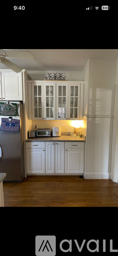 A kitchen with white cabinets and a wooden floor.