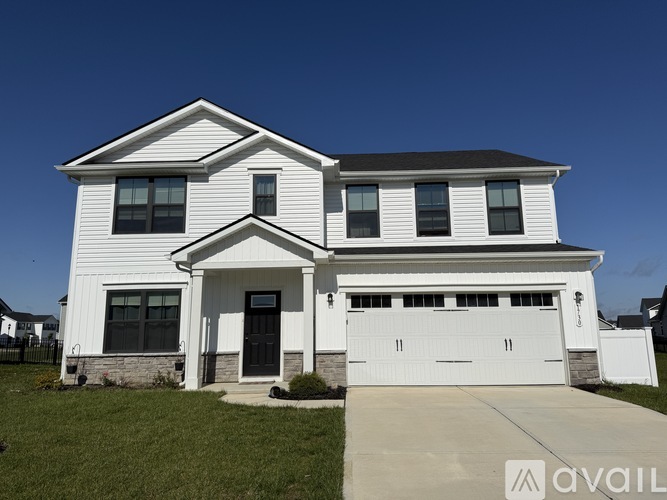 A two-story house with a white exterior and a black roof.