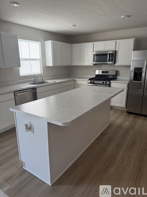 A kitchen with white cabinets and a white island.