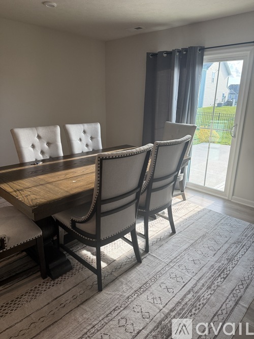 A dining room with a wooden table and chairs.