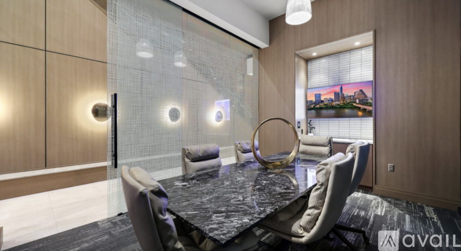 A modern dining room with a glass partition and a view of a cityscape.
