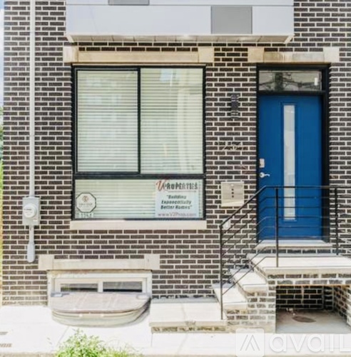 A brick building with a blue door and a window with blinds.