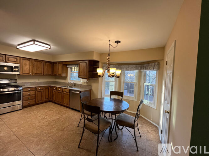 A kitchen with a table and chairs in front of a window.