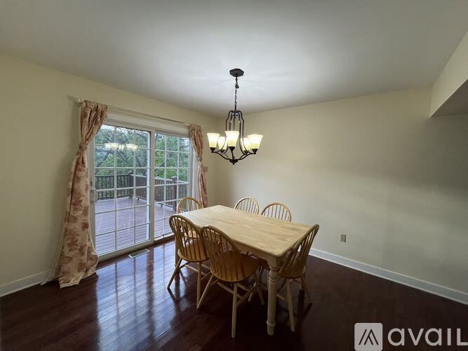 A dining room with a wooden table and chairs.