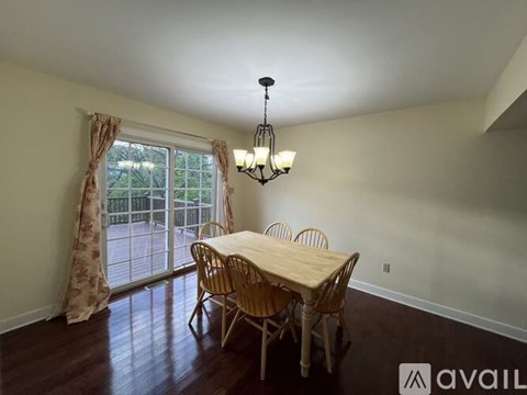 A dining room with a wooden table and chairs.