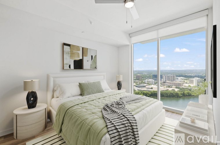 A bedroom with a large bed and a view of the city.